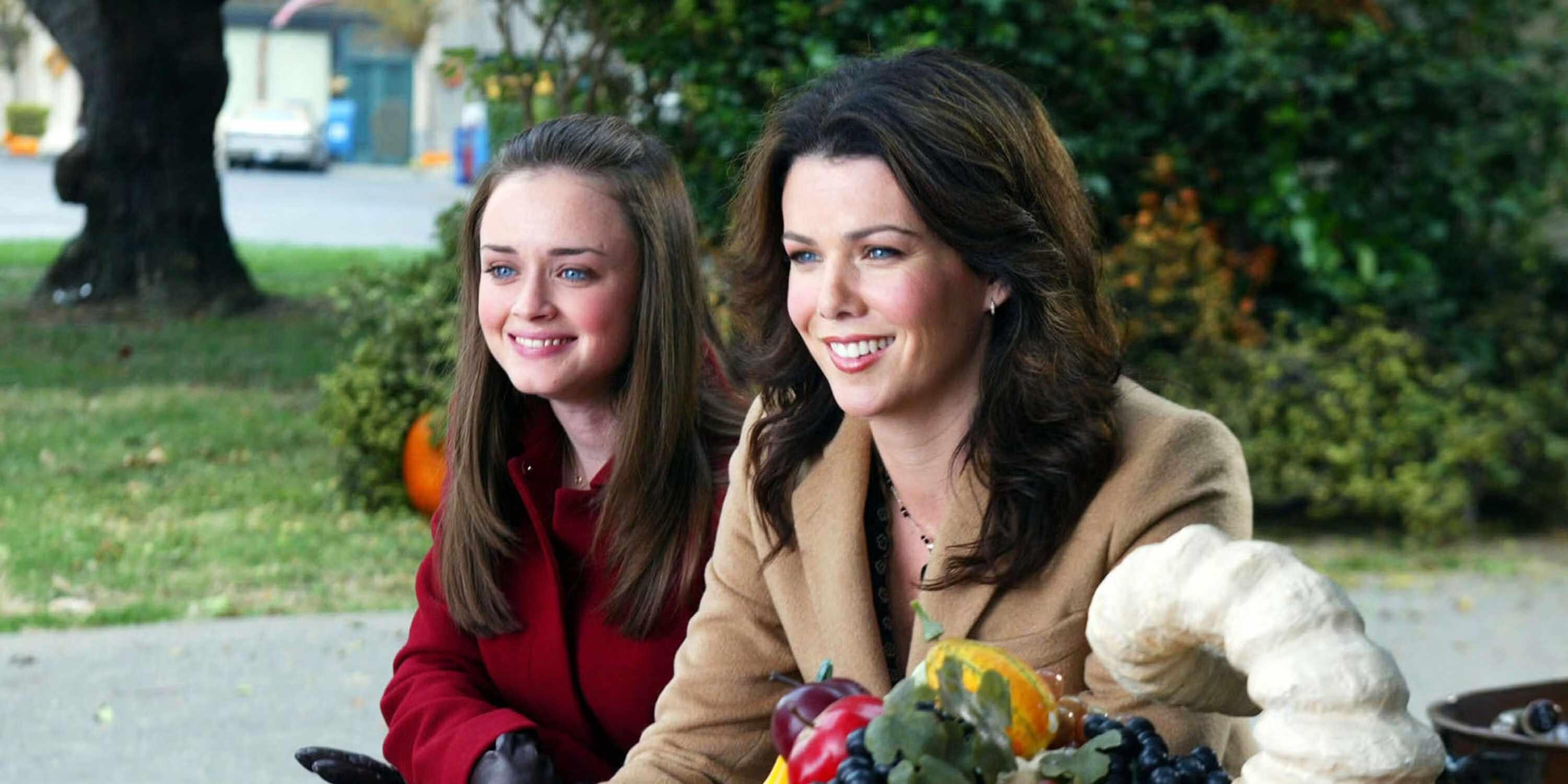 روری و لورلای در حال لبخند زدن در شام شکرگزاری سوکی در Gilmore Girls - بهترین سریال برای دوباره دیدن