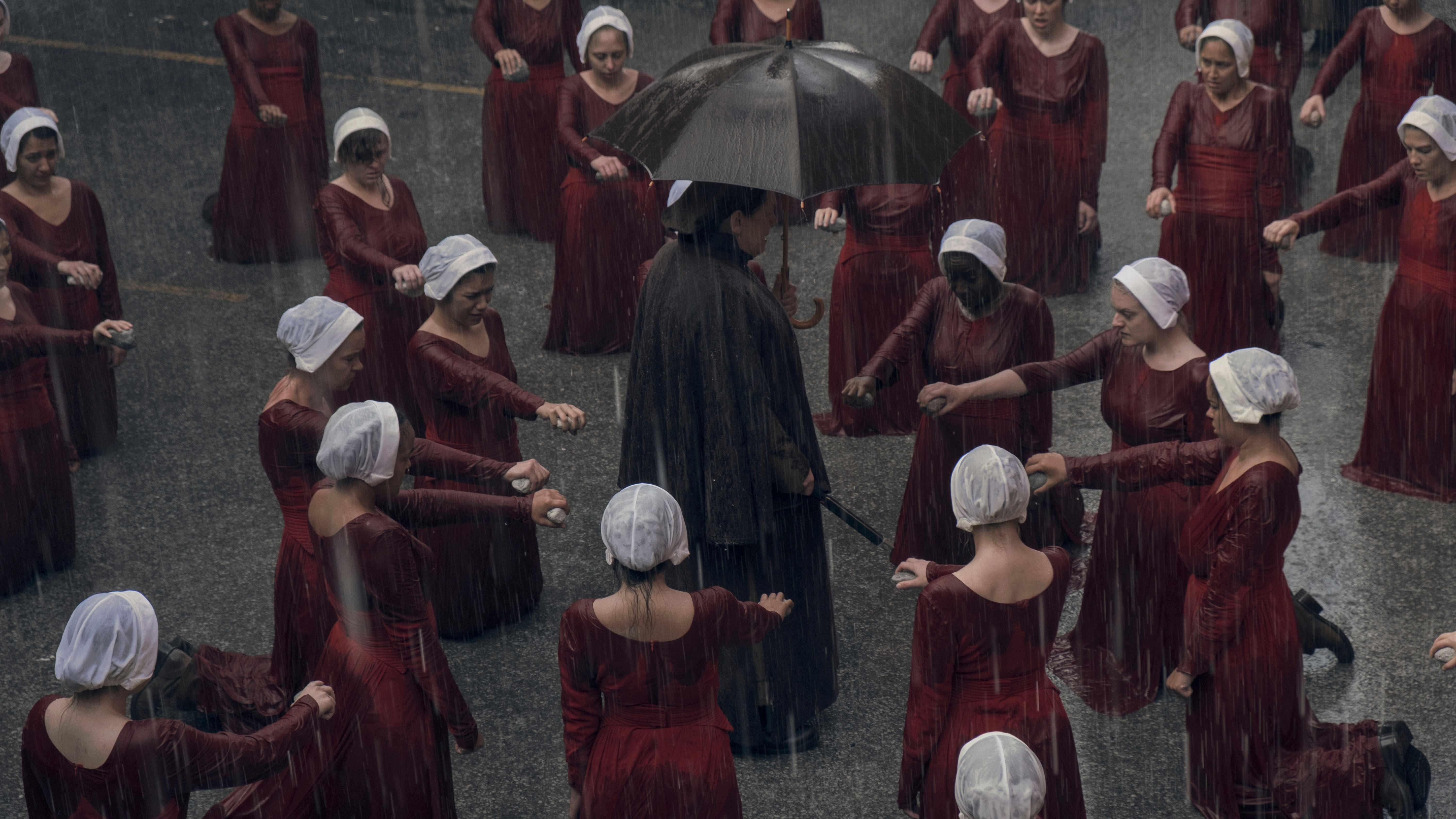 The Handmaidens kneel in The Handmaid's Tale، بهترین سریال های Hulu