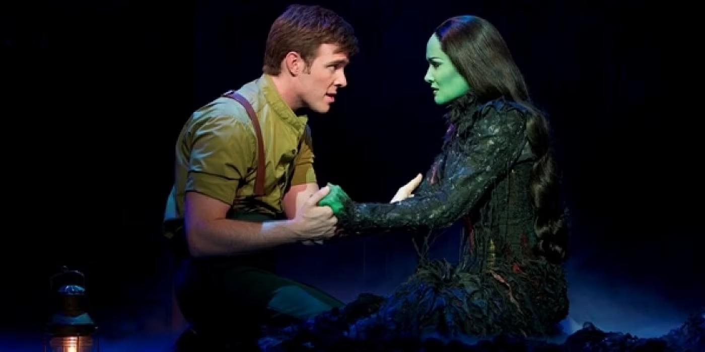 الفبا و فایرو در حال گرفتن دست یکدیگر در طول "As Long As You're Mine" از Wicked: For Good عاشقانه
