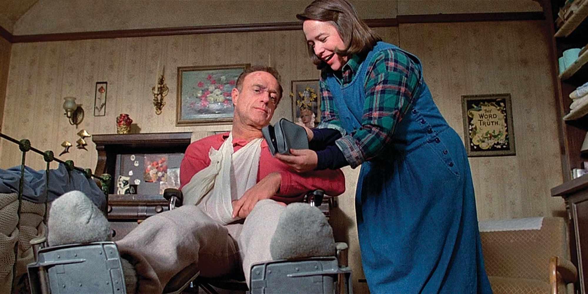 Annie چیزی را در یک کیسه به Paul نشان می دهد، در حالی که او در Misery روی ویلچر نشسته و مجروح است. Stephen King: Misery بهتر از کتاب