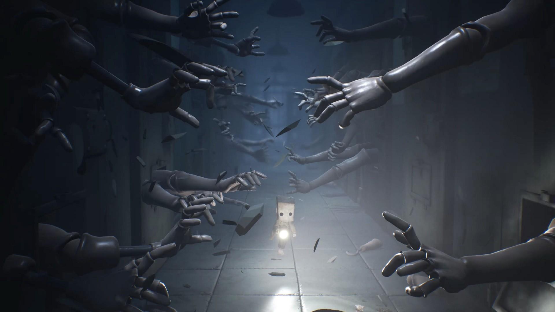 بهترین بازی های ترسناک - Little Nightmares 2 screenshot of hundreds of mannequin arms reaching out down a long corridor as the player character walks down it
