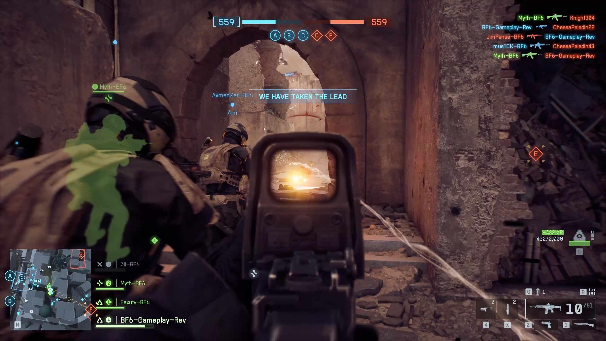 گیم پلی چندنفره Battlefield 6 بازگشت به ریشه ها که بازیکنی را در حال نگاه کردن از طریق دوربین تفنگ خود نشان می دهد، در حالی که سه متحد در کنار او یک خیابان باریک را پاکسازی می کنند
