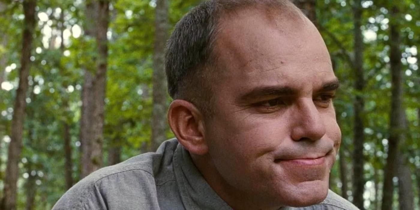 کارل (بیلی باب تورنتون) در حالی که در جنگل نشسته است، در Sling Blade، یکی از بهترین فیلم های Billy Bob Thornton نگاه می کند