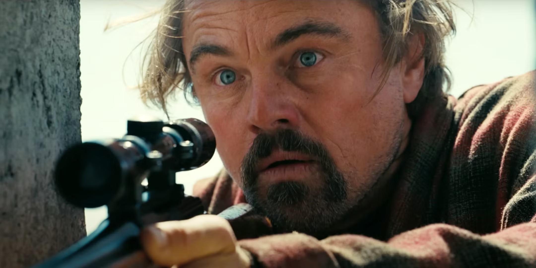 Leonardo DiCaprio looking shocked while holding a rifle in One Battle After Another معنی پایان