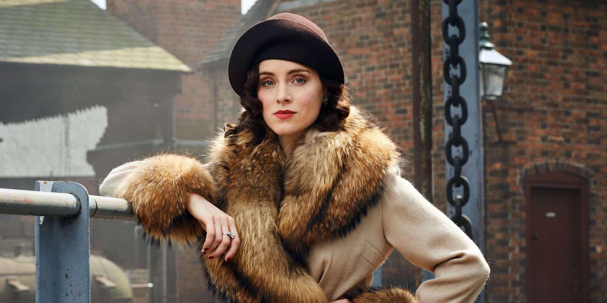 سوفی راندل در حال تکیه دادن به نرده و پوشیدن کت لبه خز در Peaky Blinders. Peaky Blinders تعلیق و پایان بندی.