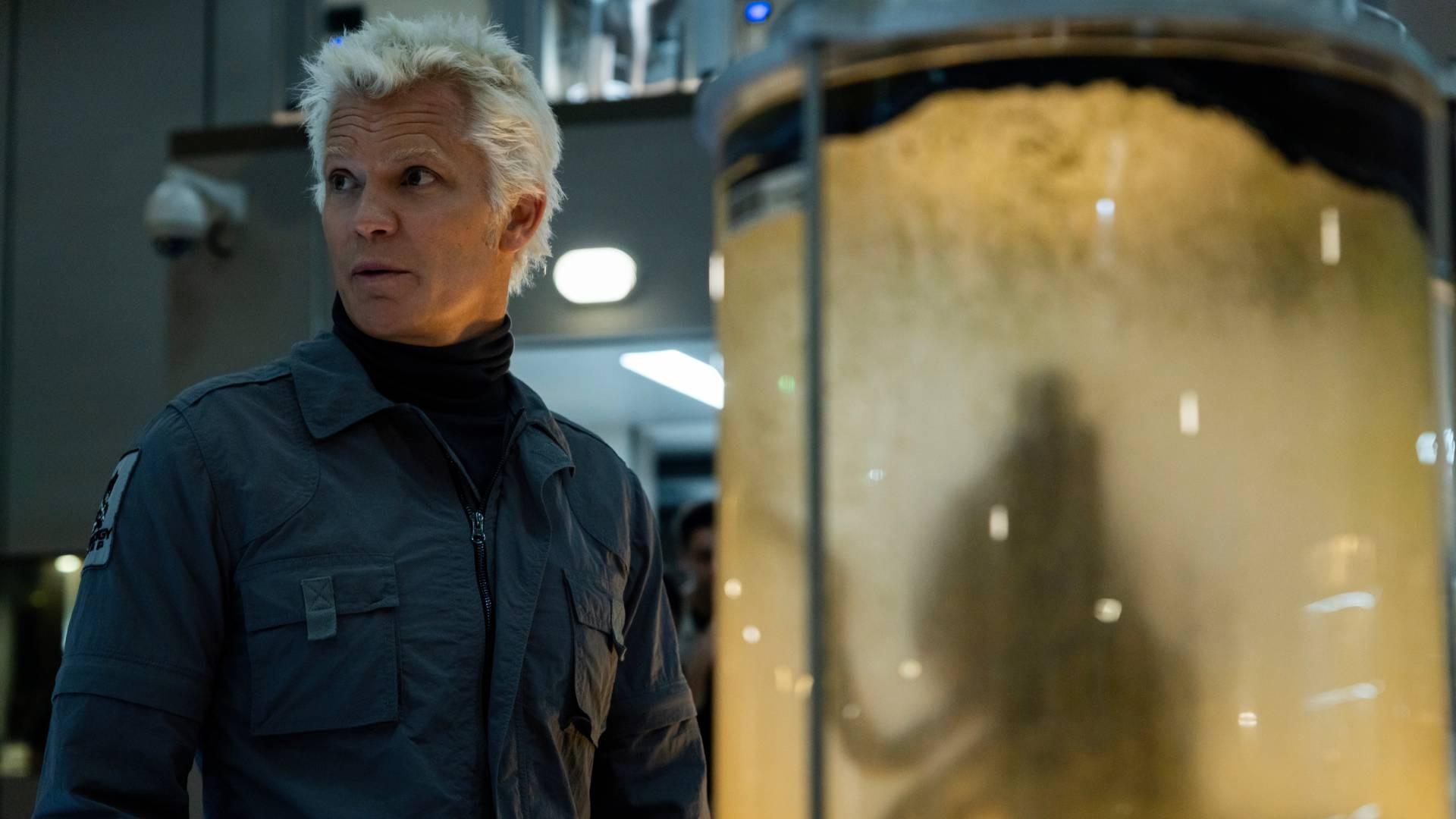 Timothy Olyphant در نقش Kirsh در سریال Alien: Earth ایستراگ، ایستاده در مقابل یک کانتینر حاوی نمونه بیگانه.