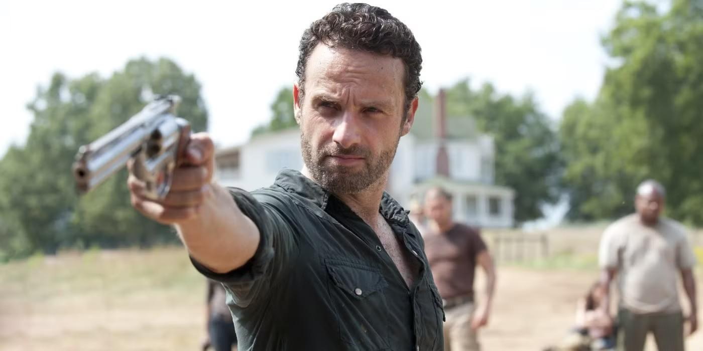 بازی Andrew Lincoln در The Walking Dead: اندرو لینکلن در نقش ریک گرایمز که اسلحه به دست گرفته است