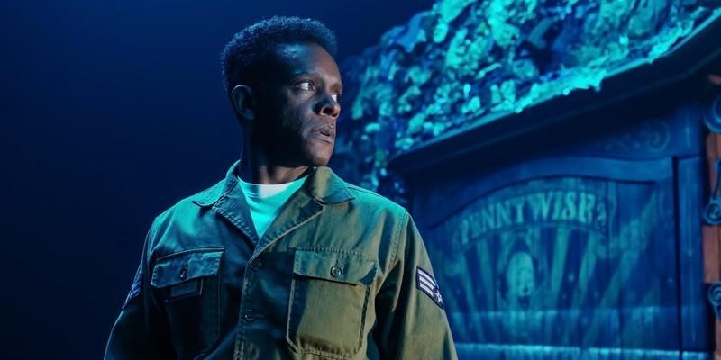 مردی جلوی یک تبلیغ پنی وایز در It Welcome to Derry ایستاده است؛ بررسی هدیه Dick Hallorann در IT: Welcome to Derry.