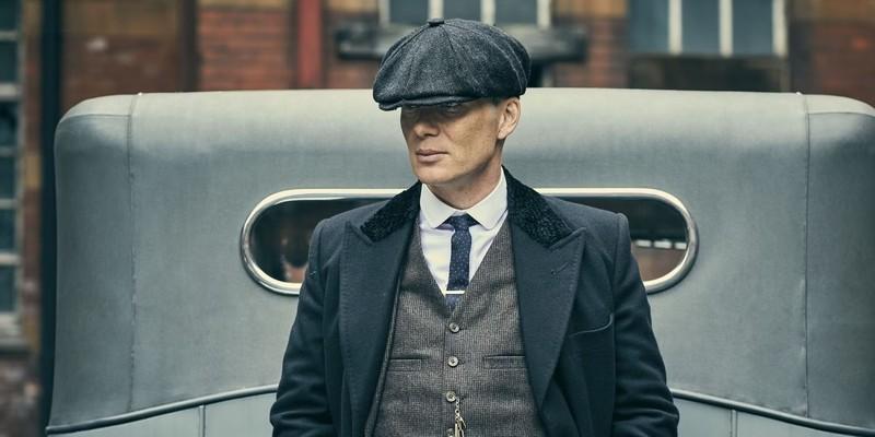 کیلین مورفی در حال تکیه دادن به ماشینی در Peaky Blinders، از سریال هایی بهتر از The Sopranos.