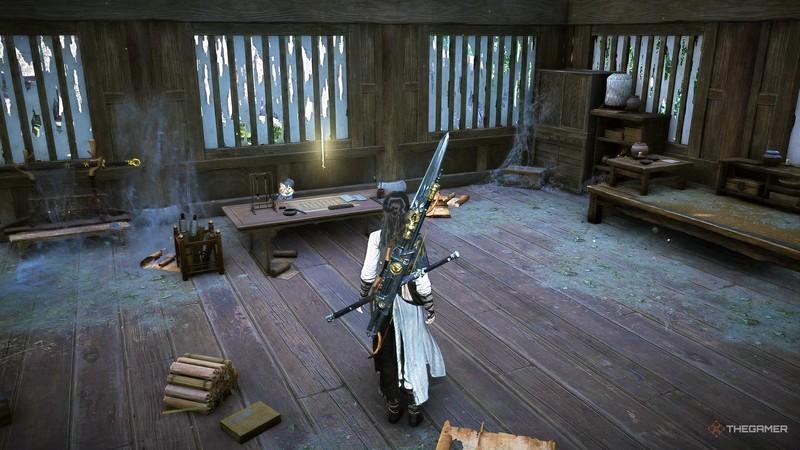 گربه ای پشت میز در خانه ای در Where Winds Meet راهنمای کامل Meow Meow نشسته است.