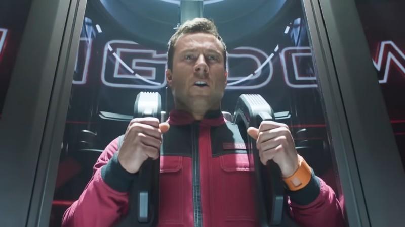 ریچاردز در حال آماده شدن برای پرتاب شدن به داخل یک لوله در The Running Man قیافه در هم کشیده است - تفاوت فیلم و کتاب The Running Man