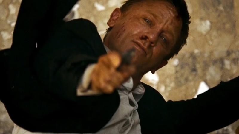 Bond aims his gun while hanging from a roof in Quantum of Solace, یک صحنه اکشن نجات بخش James Bond
