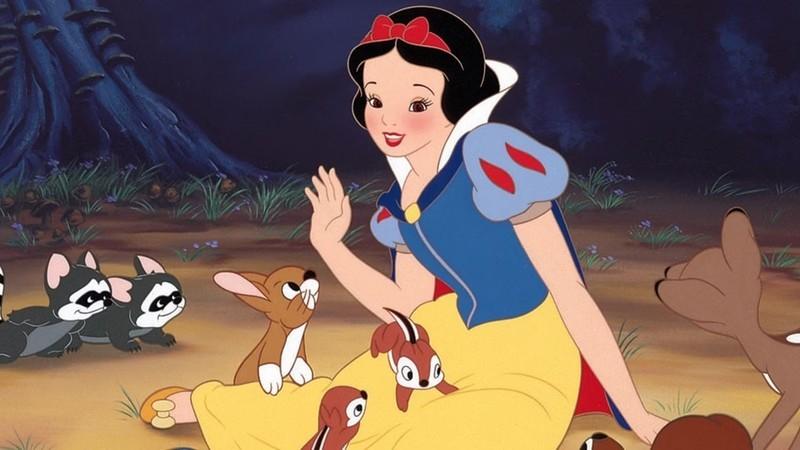 «سفیدبرفی» در کنار موجودات جنگلی در Snow White and the Seven Dwarfs نشسته، یکی از برترین انیمیشن های اولیه Disney
