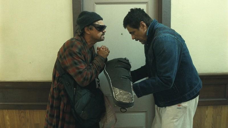 تعظیم باب و سنسه به همدیگه در حالی که سنسه تفنگش رو در فیلم One Battle After Another به اون می ده. تصویری مرتبط با اولین اسکار پال توماس اندرسون.