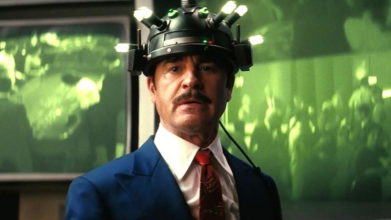 مستر هاوس با بازی جاستین ثرو با دستگاهی روی سرش که جلوی یک صفحه نمایش بزرگ در فصل 2 Fallout – Fallout بهترین سریال