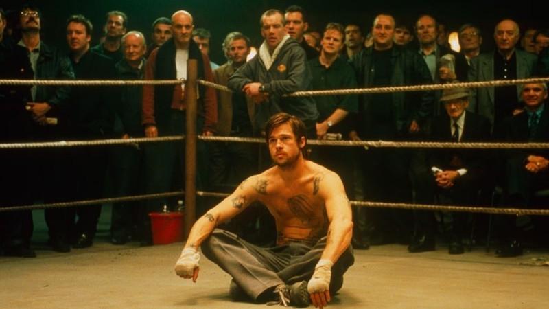 چرا Snatch هنوز جذاب است: میکی (برد پیت) در رینگ نشسته و مردم در Snatch تماشا می کنند.