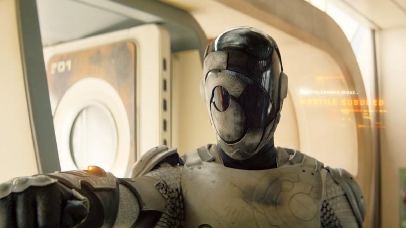 الکساندر اسکارشگارد در نقش مردربات با کلاهخود بسته و متنی که می گه "دشمن مغلوب شد" در فصل 1 Murderbot - Murderbot فصل 2 سایبرپانک