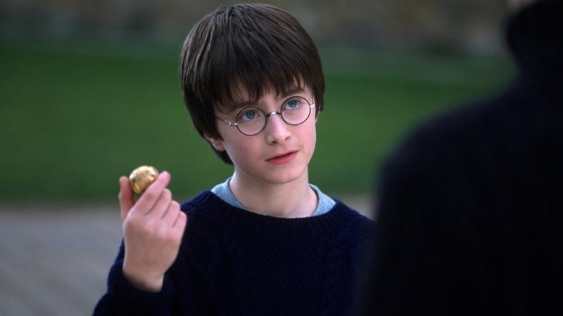 هری پاتر با اسنیچ طلایی در Harry Potter and the Sorcerer's Stone، نمادی از کوییدیچ سریال Harry Potter